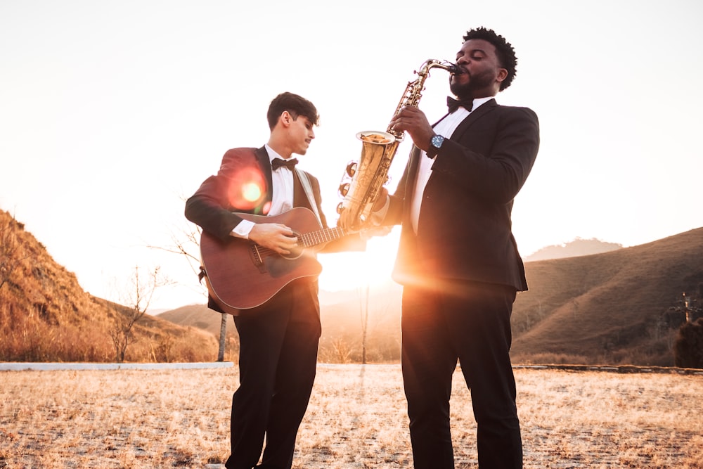 two men playing saxophone and guitar