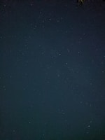 A dark midnight blue night sky with twinkling stars, framed by cozy curtains.