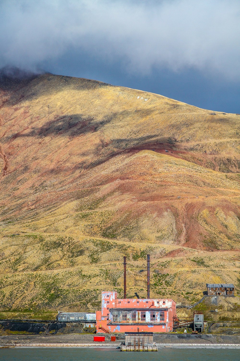 un bâtiment rouge assis au sommet d’une colline verdoyante