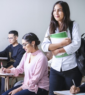 woman carrying white and green textbook