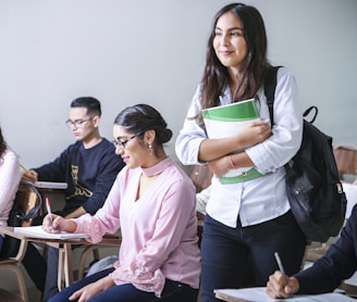 woman carrying white and green textbook