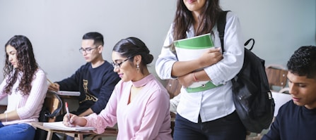 woman carrying white and green textbook