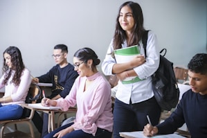 woman carrying white and green textbook