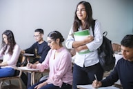 woman carrying white and green textbook