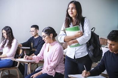 woman carrying white and green textbook