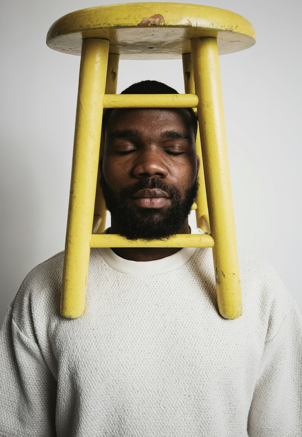 yellow wooden stool on man's shoulder