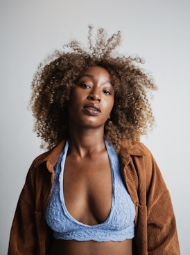 woman wearing blue lace bralette and brown corduroy cardigan