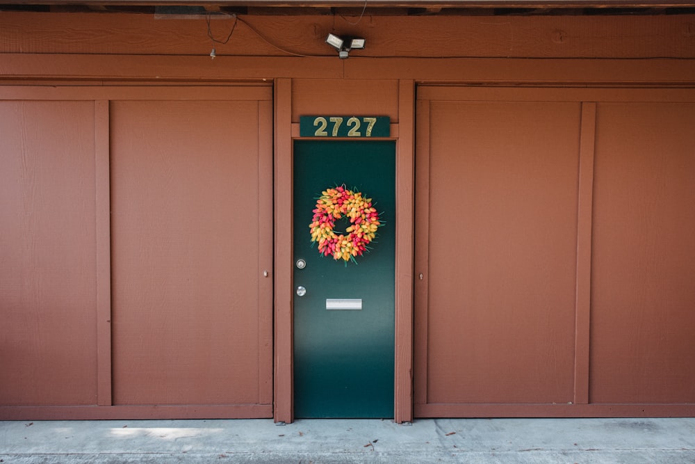 a green door with a wreath on it