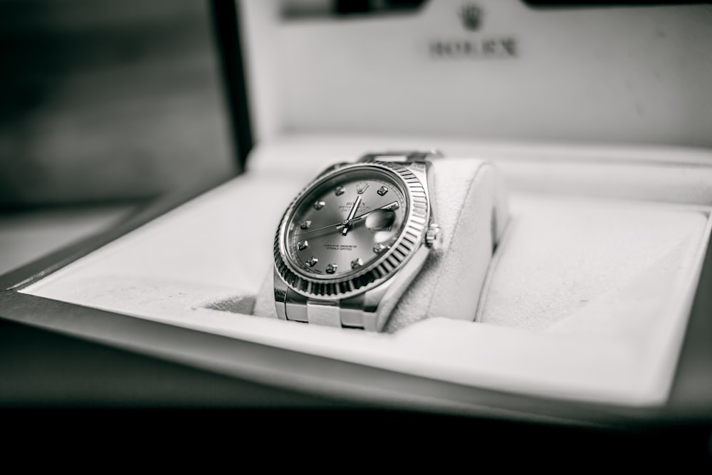 grayscale photo of Rolex watch in box