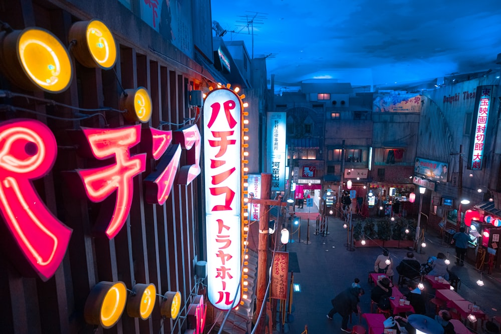 people by tables beside buildings under gray skies