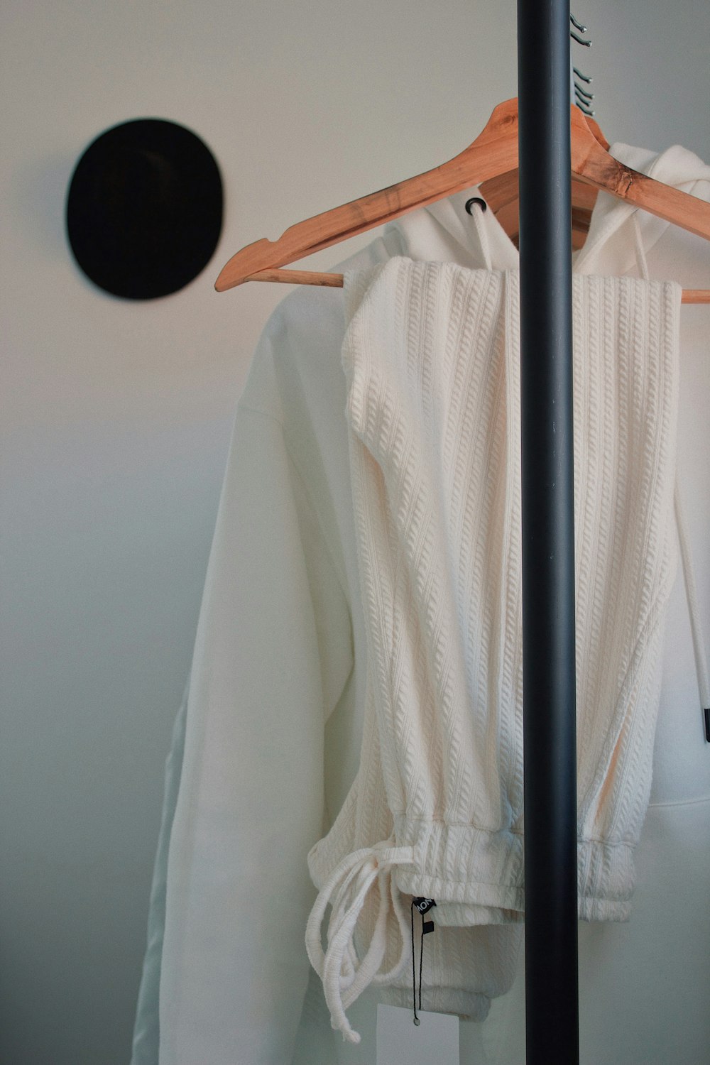 white drawstring jeans and hoodie on hanger