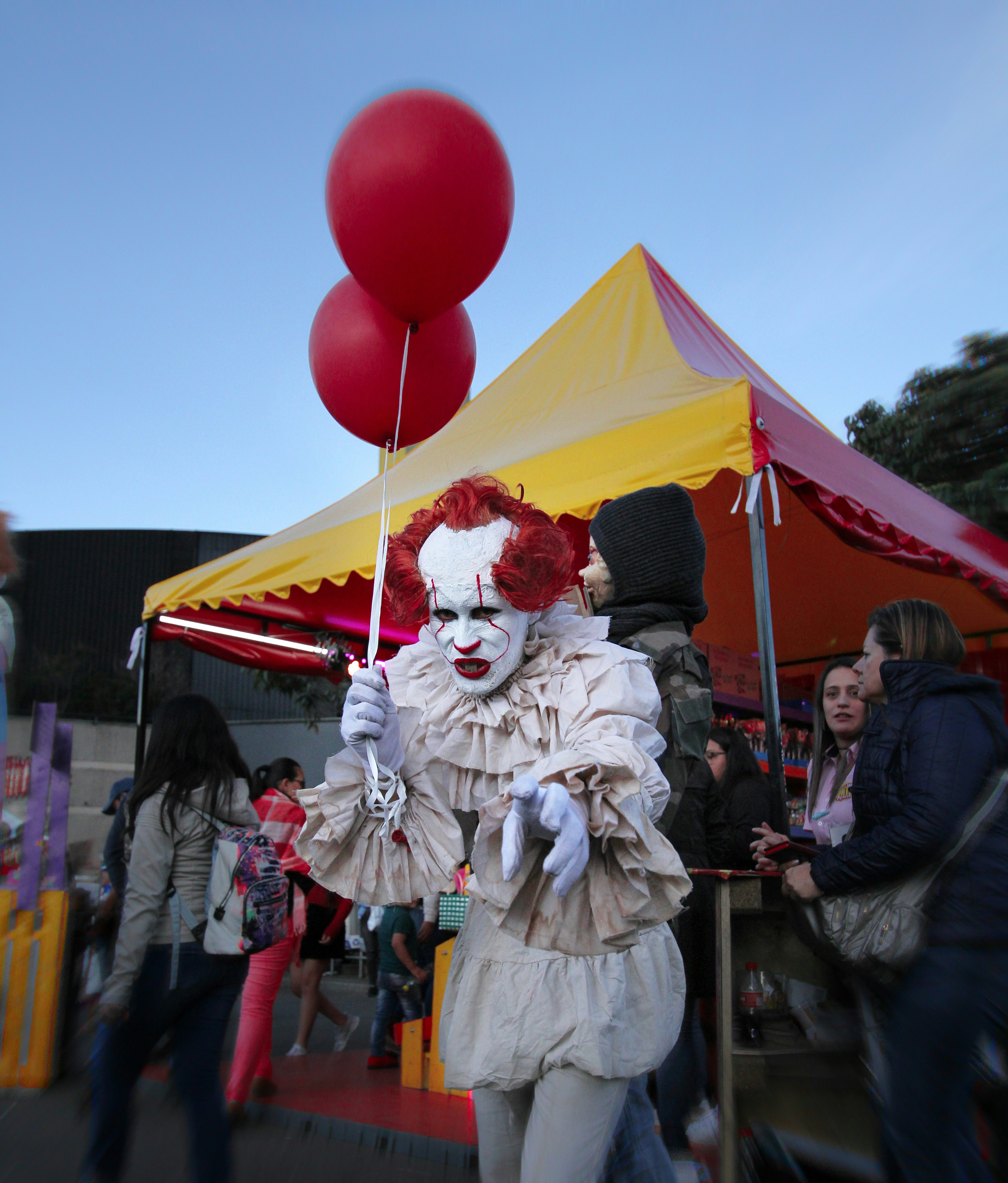clown holding two red balloons