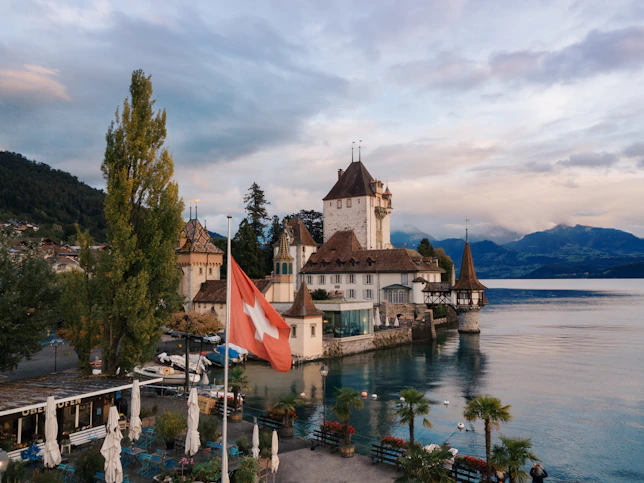 white and brown building beside calm body of water