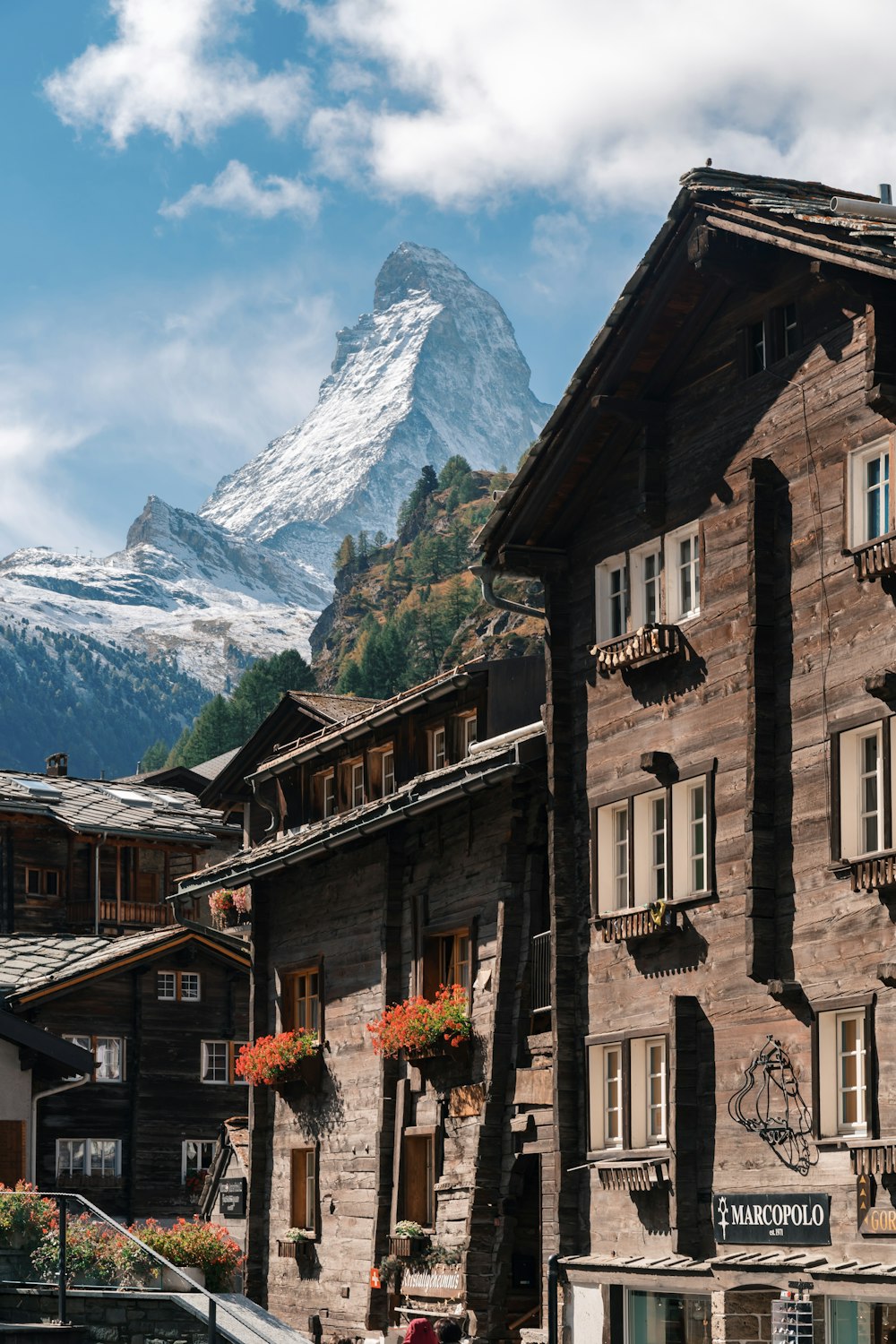 case marroni che osservano la montagna sotto il cielo blu e bianco durante il giorno