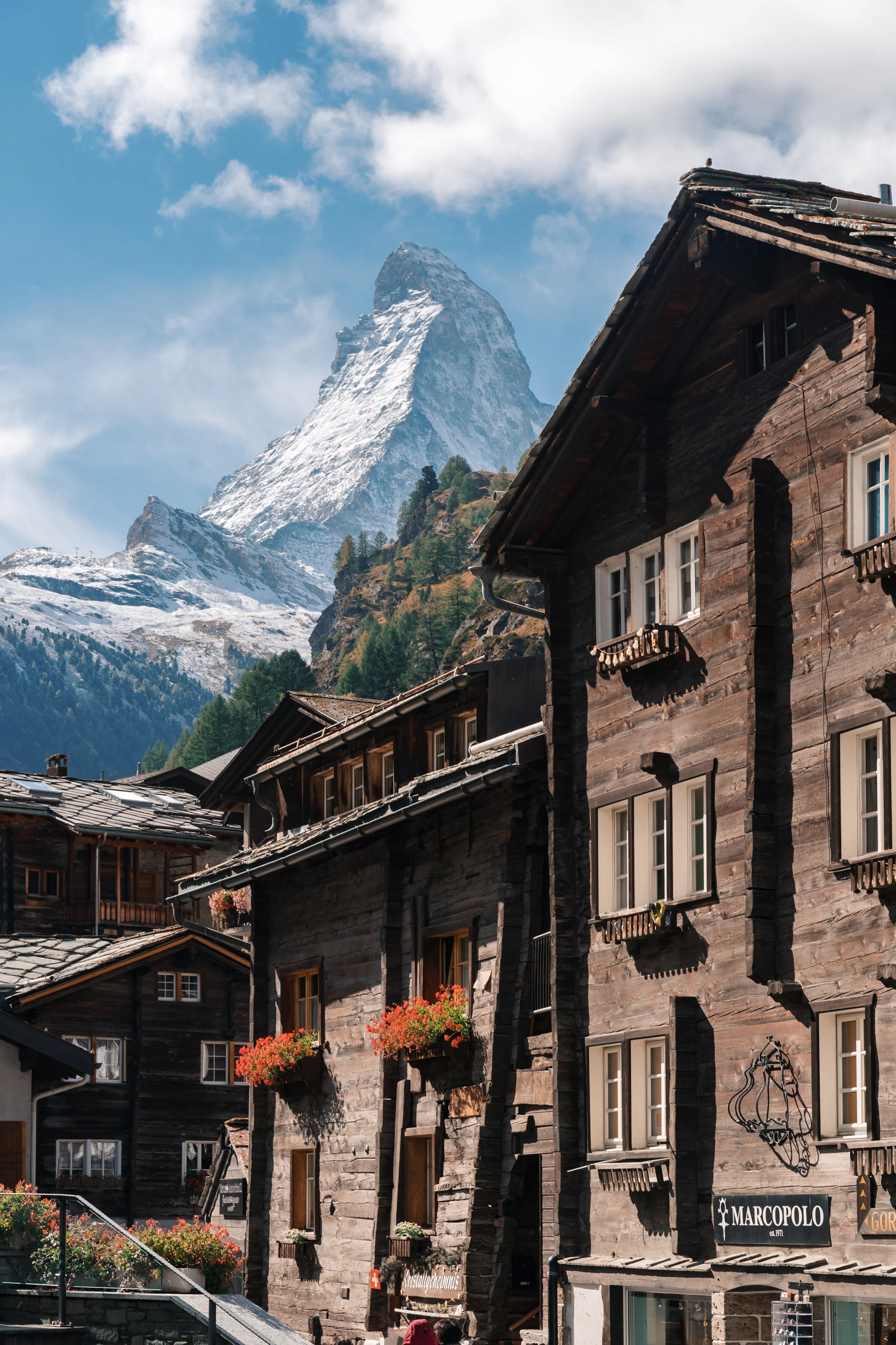 Old timber chalets in Zermatt with the Matterhorn rising at the end of the street