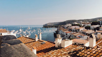 white boat lot on sea beside mountain