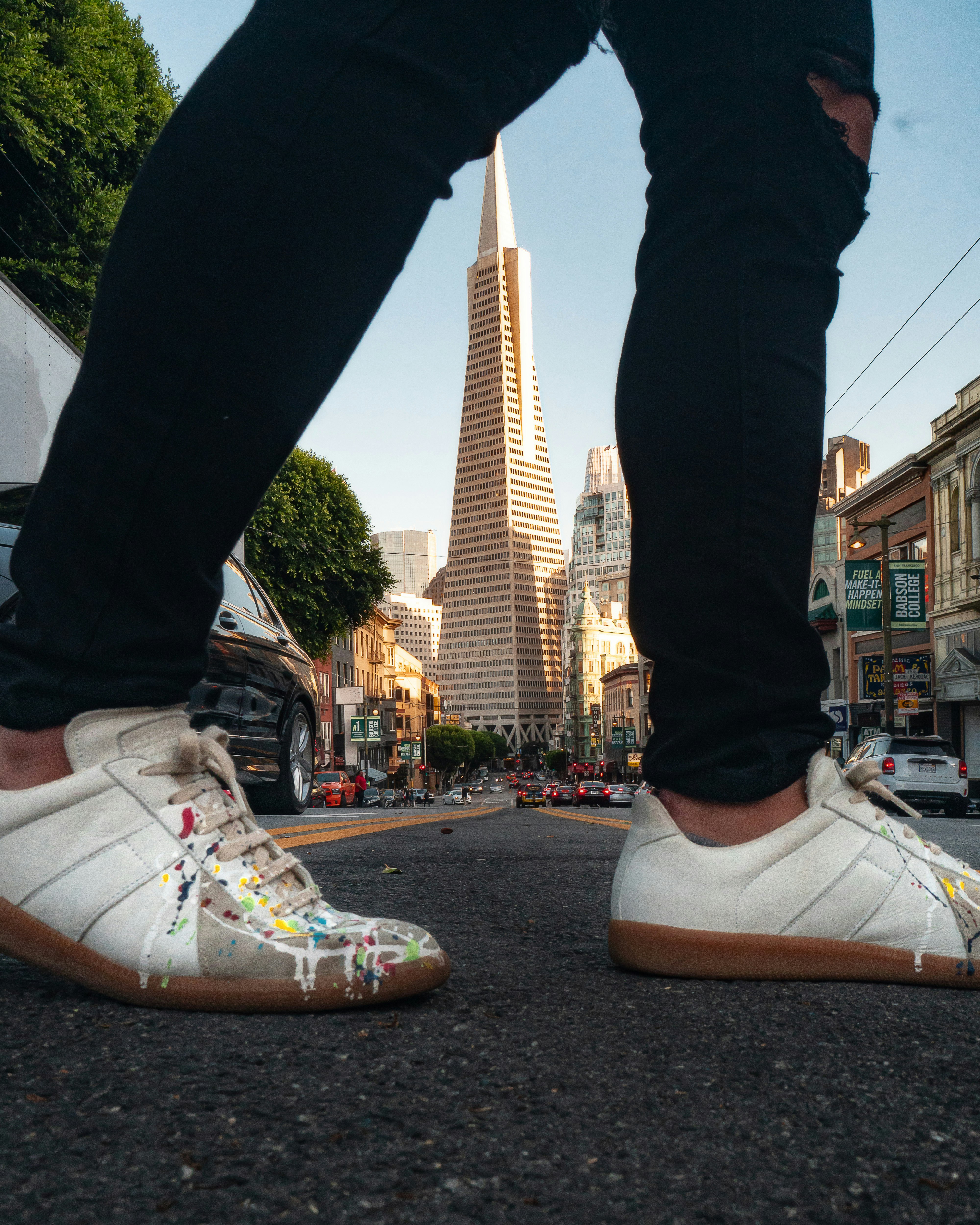 person in black pants and white nike sneakers