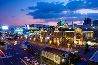 A nighttime shot of an illuminated train station featuring bold architecture and dynamic lighting.