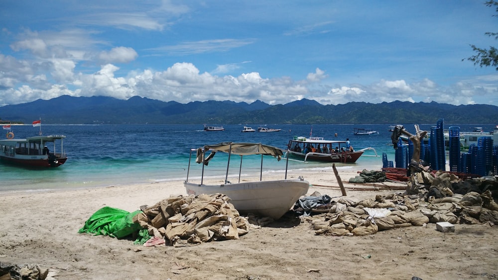 white boat near body of water at daytime