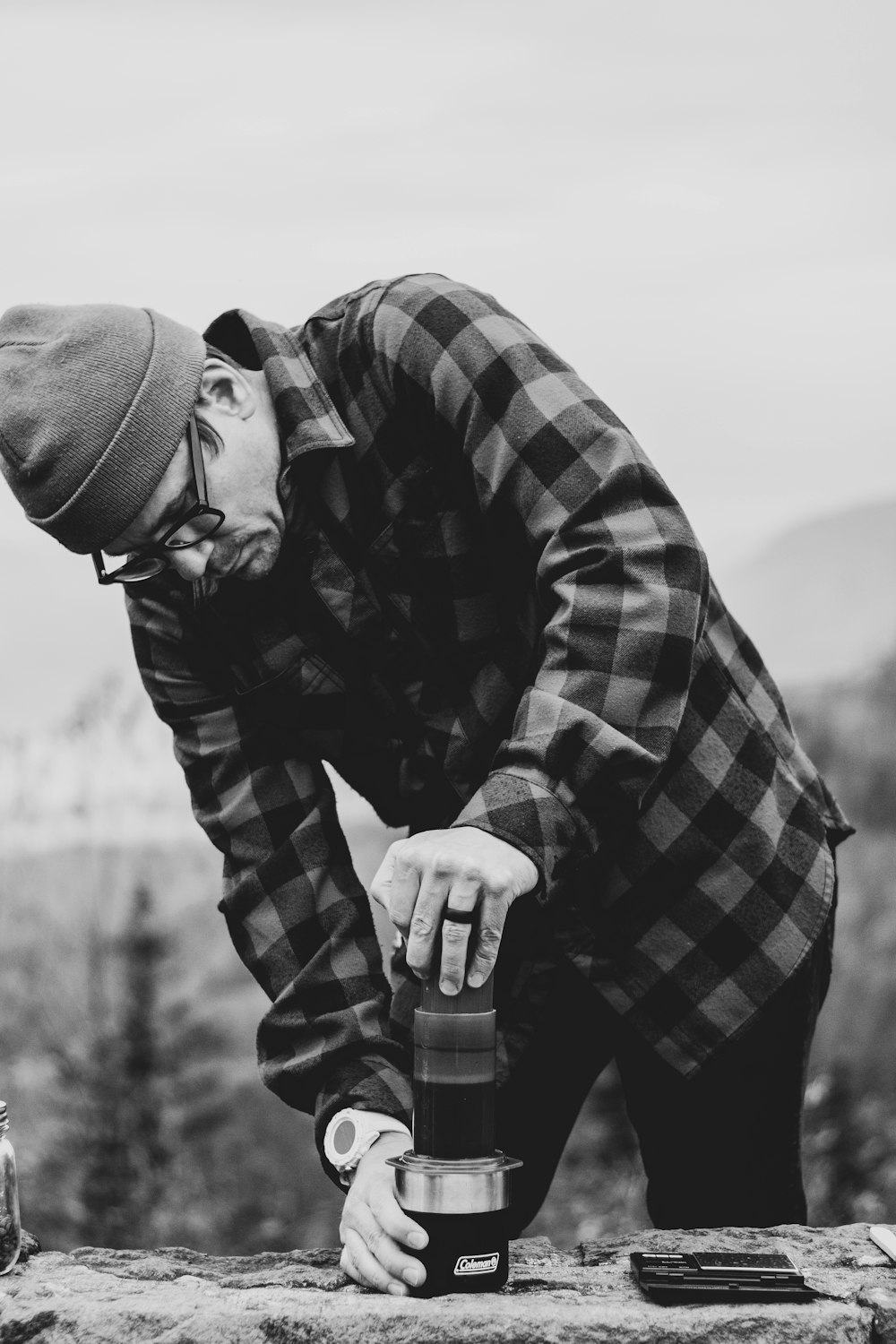 grayscale photo of man holding container