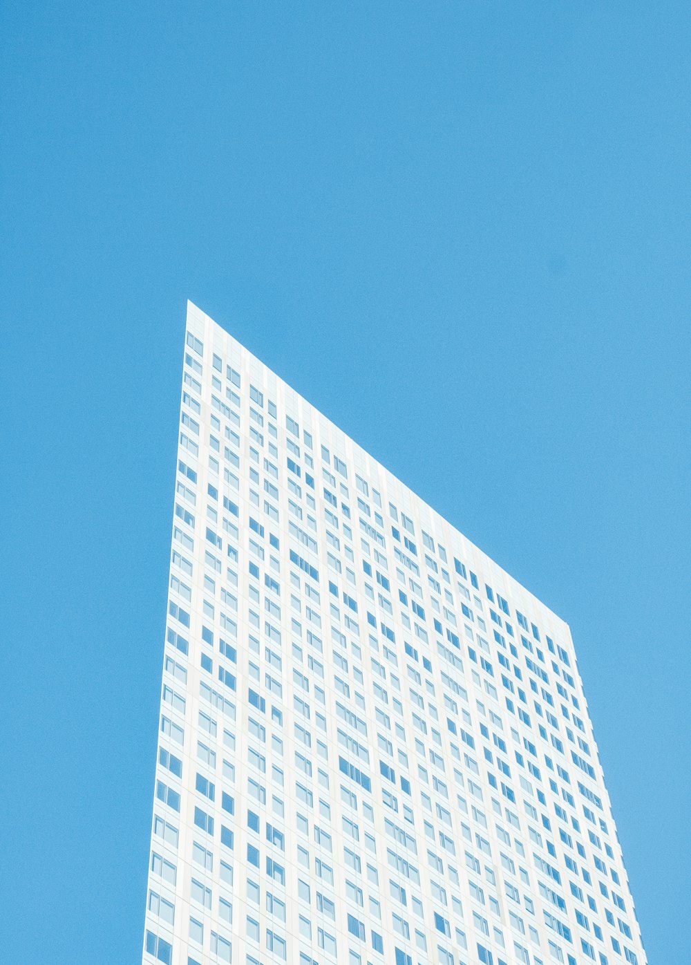 昼間の白と青の高層ビル