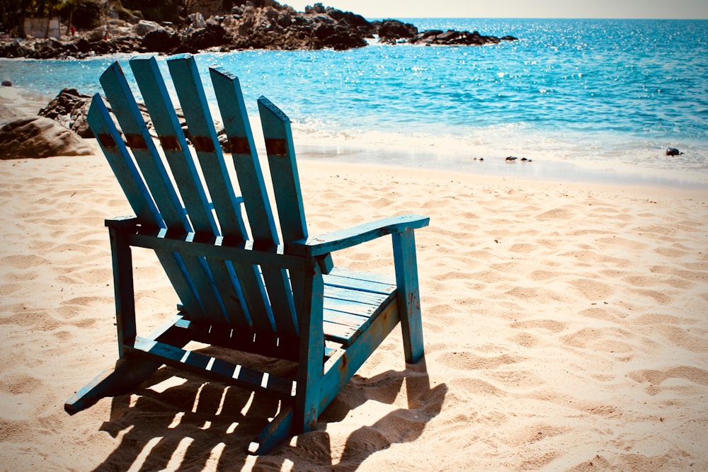 blue Adirondack chair on seashore