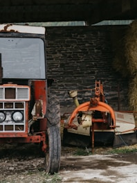 A rugged tractor being thoroughly washed in a rural farm environment.