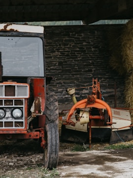 A rugged tractor being thoroughly washed in a rural farm environment.