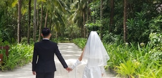 groom and bridge walking on walkway during daytime