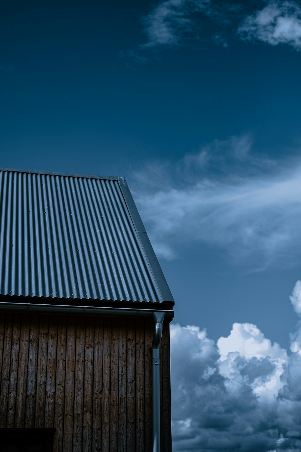 a building with a metal roof under a cloudy sky