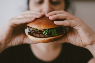 person holding burger hungry zoom background