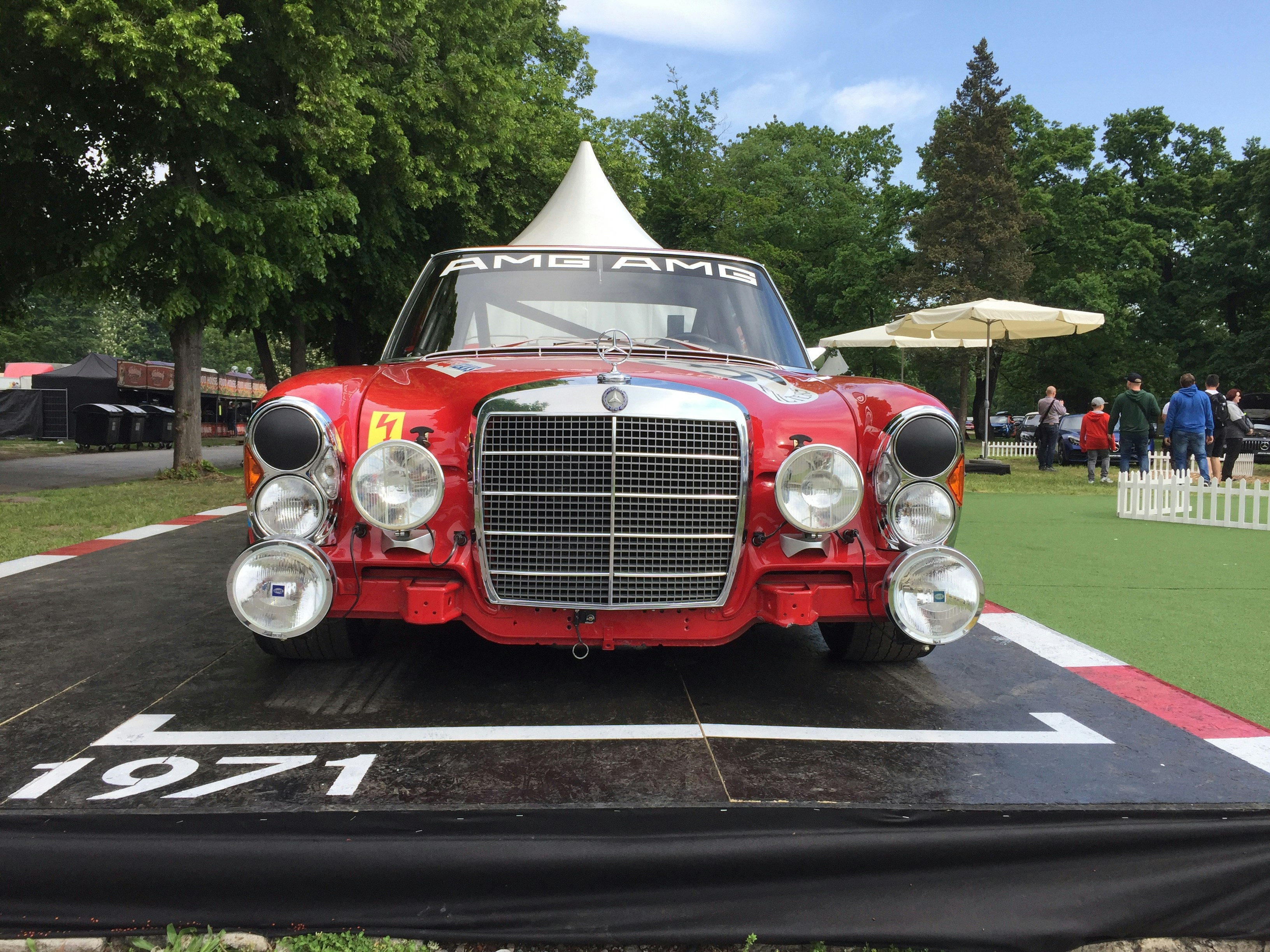 classic red car on road near people