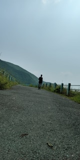 A serene outdoor scene with a person walking alone thoughtfully.