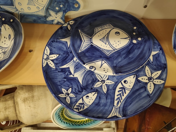 Artisan-crafted plates with subtle ocean hues and delicate wood accents.