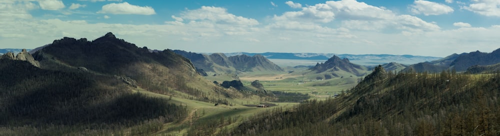 panoramic view of green grassy hills during cloudy day