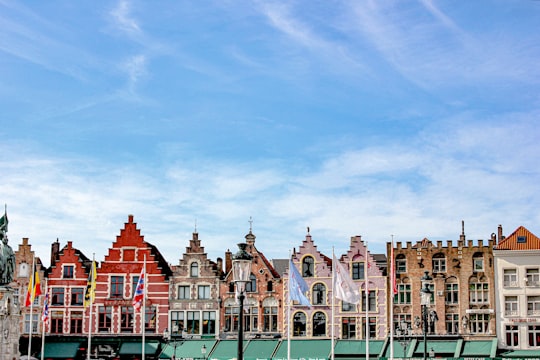 brown painted buildings under blue sky in Plaza Gran Mercado Belgium