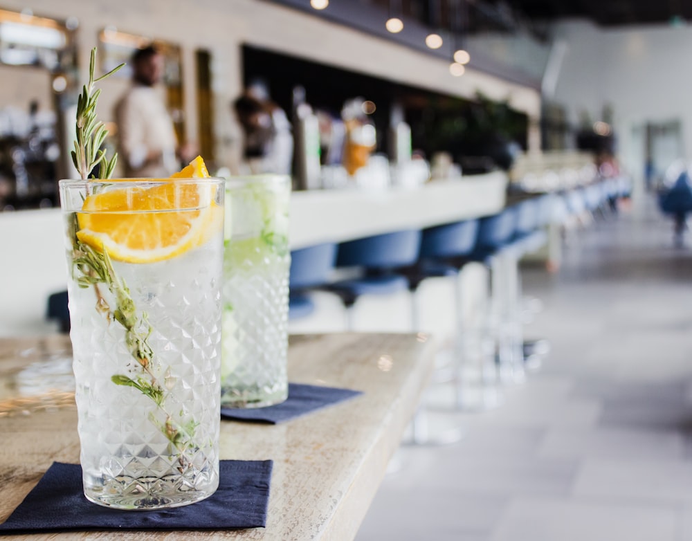 clear drinking glass filled with white liquid and sliced lemon