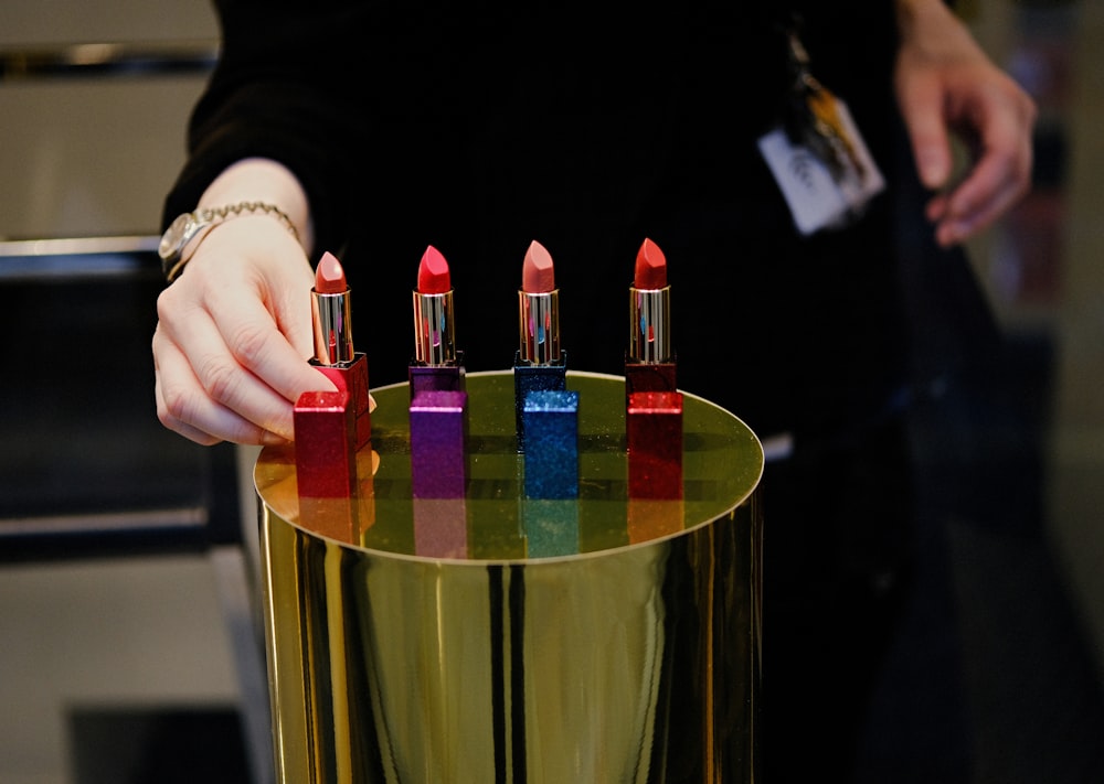 person holding red lipstick