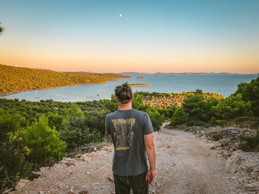 man standing front of sea during daytime