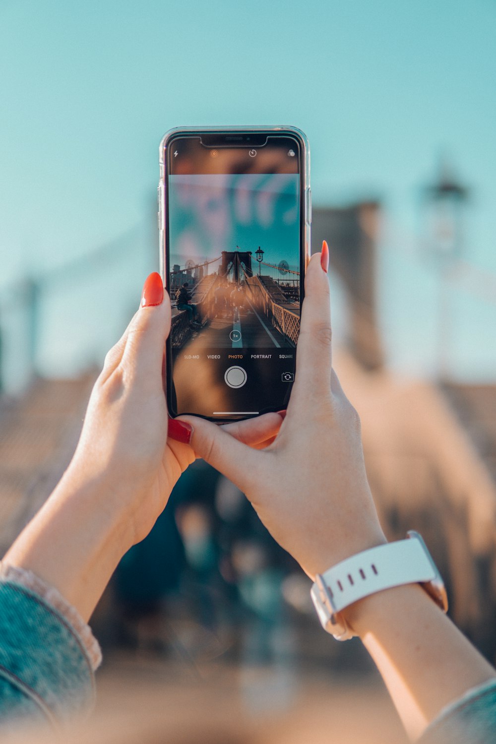 person taking picture of Brooklyn bridge