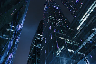 A sleek, dark city skyline at night with subtle blue and silver lighting reflecting a futuristic urban vibe.