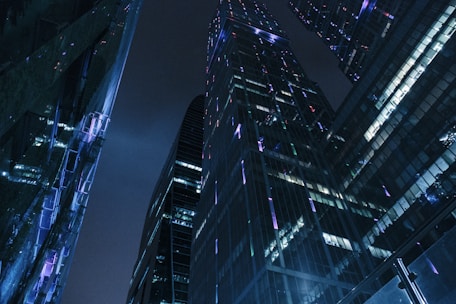 A sleek, dark-toned city skyline at night with subtle silver highlights reflecting off glass surfaces.