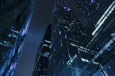 A sleek, holographic cityscape with neon lights reflecting in dark glass surfaces.