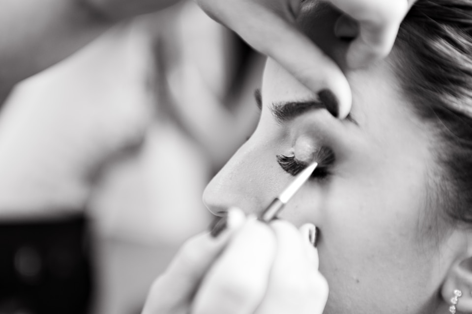 A woman getting her makeup done, black and white photo