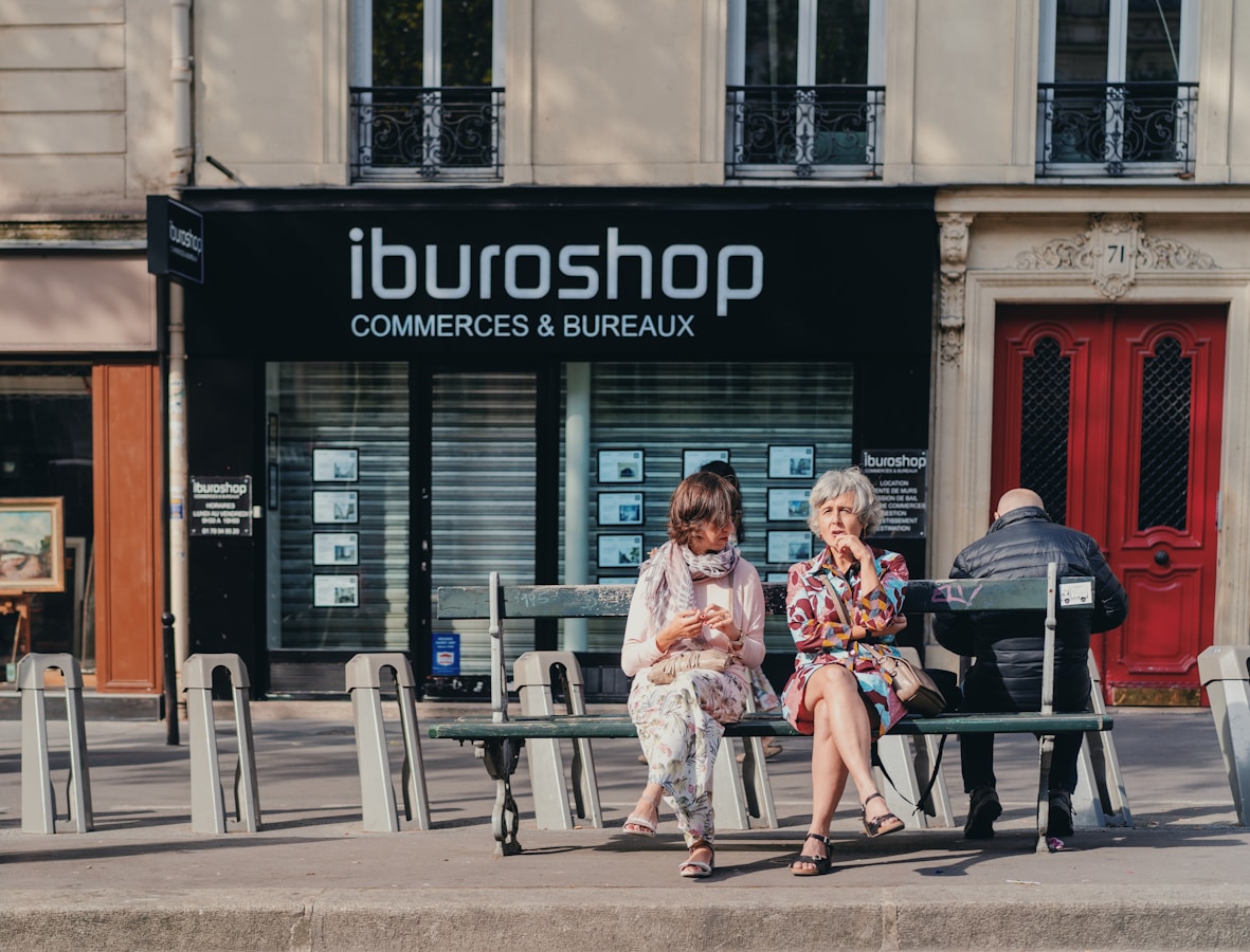 two woman sitting on the bench near the iburoshop