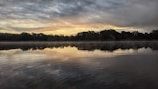A serene landscape with a sunrise illuminating a tranquil lake.