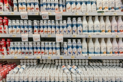 Fresh dairy products including milk bottles and yogurt cups on a market stall.