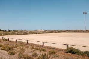 Close-up of a sturdy Sportela portable football goal set up on a grassy field under a clear sky.