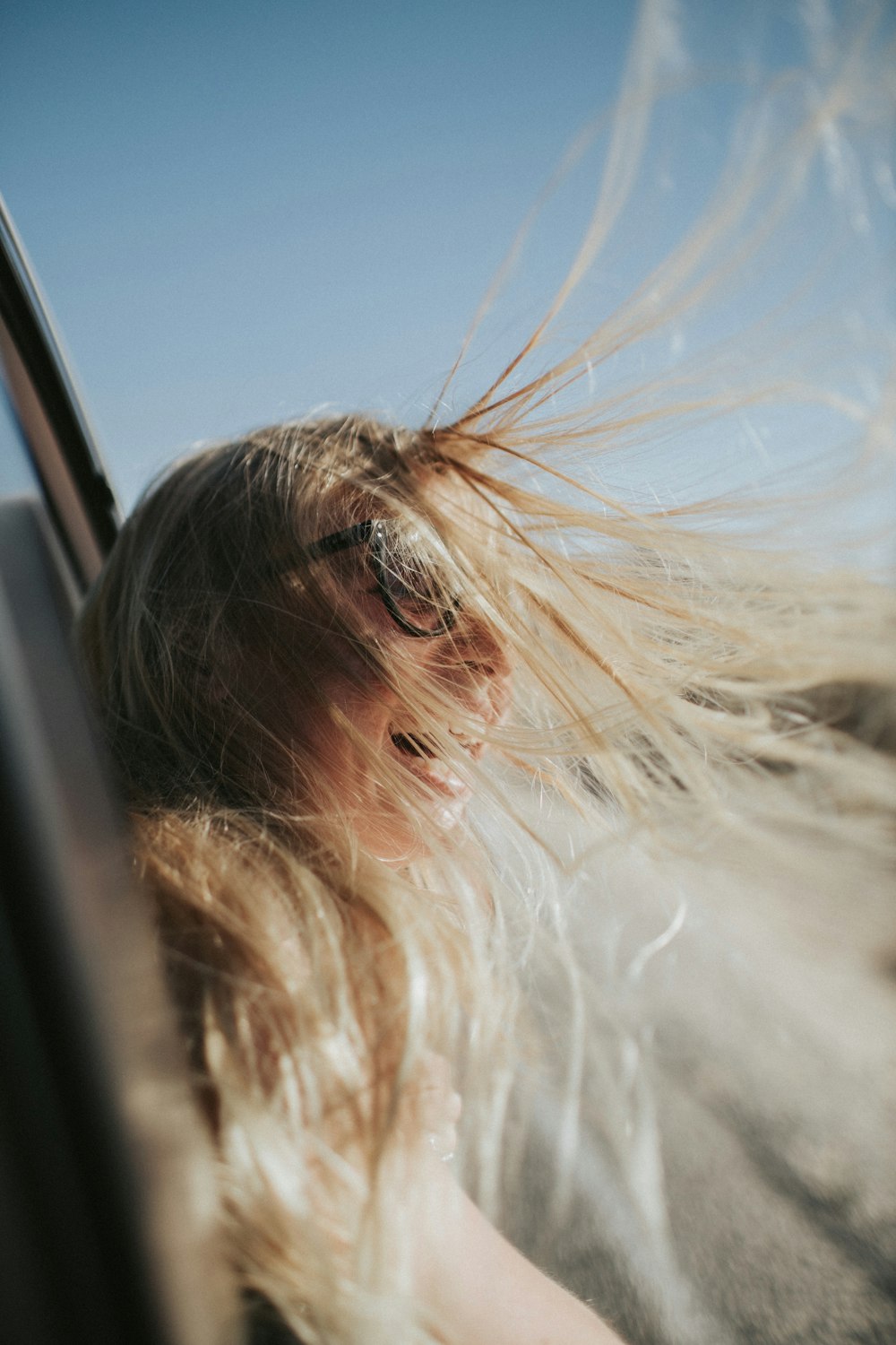 smiling woman wearing black eyeglasses riding on vehicle