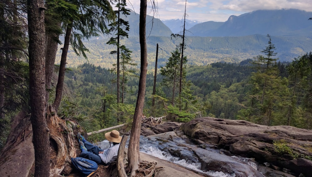 person wearing brown hat sitting near river